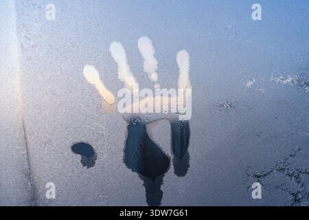 A handprint on a frozen winter window Stock Photo
