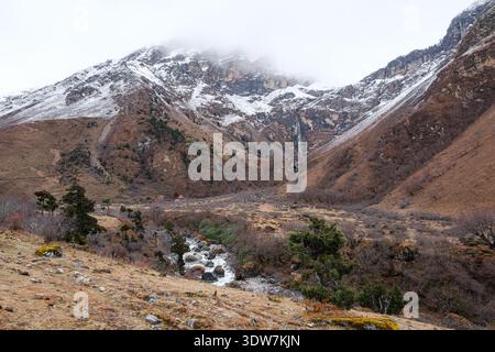 Snowy mountains, Paro River, waterfall and small temple from the Jomolhari Trekking Trail, Bhutan just below Jomolhari Base Camp. Stock Photo