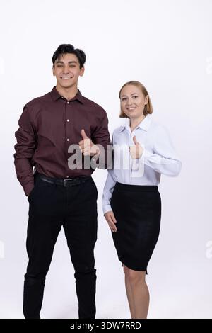 Young couple in formal clothes posing and pointing aside Stock Photo