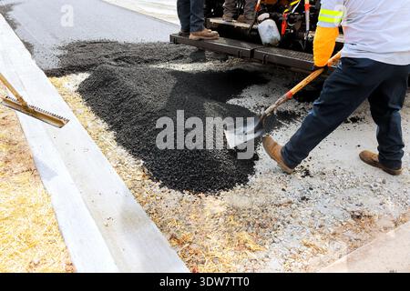 Workers are laying asphalt to repair road, using tools equipment Stock Photo