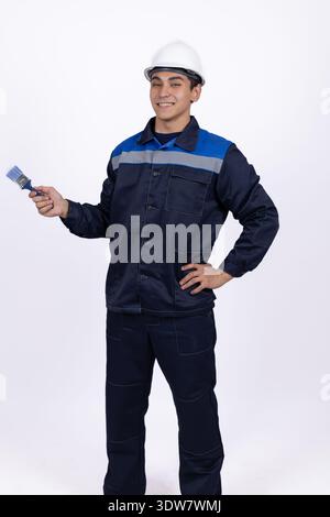 Electrician in blue uniform holding screwdriver and wire Stock Photo