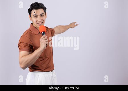 Young man in maroon shirt talking into orange megaphone Stock Photo