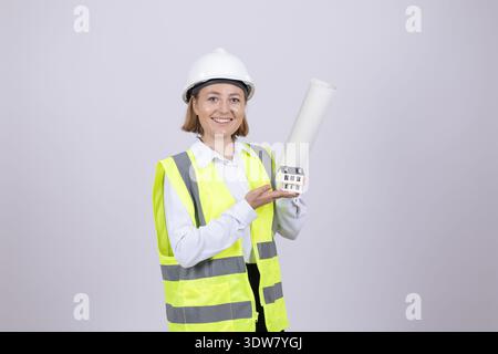 Woman in safety vest and helmet holding paper roll Stock Photo