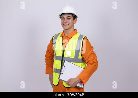 Worker in orange uniform and hard hat holding clipboard Stock Photo