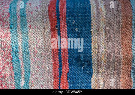 Traditional rustic carpet with a striped pattern.Background of multi-colored homespun rug. Traditional rustic very long carpet . Stock Photo