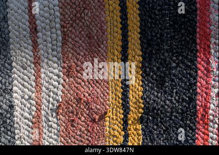 Traditional rustic carpet with a striped pattern.Background of multi-colored homespun rug. Traditional rustic very long carpet . Stock Photo