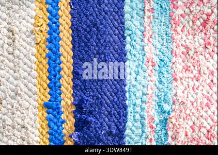 Traditional rustic carpet with a striped pattern.Background of multi-colored homespun rug. Traditional rustic very long carpet . Stock Photo