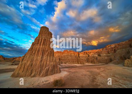 Cathedral Gorge Rock Formation at Golden Hour with Dramatic Clouds and Desert Landscape Stock Photo