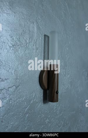 Smart eco-friendly lamp with motion sensor on the gray decorative wall. Stock Photo