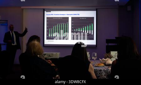 People seated at breakfast table watching a man give a Powerpoint  business presentation in Mexico Stock Photo