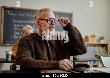 Middle Aged Caucasian Man Attending Class and Listening during Lesson Stock Photo