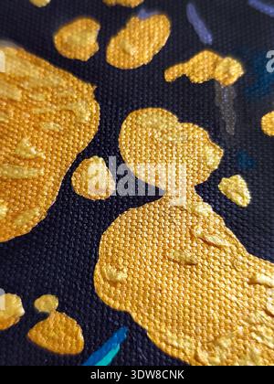 Close-up of abstract acrylic painting with textured gold, blue, and black strokes on canvas, showing detailed brushwork and vibrant color contrast. Stock Photo