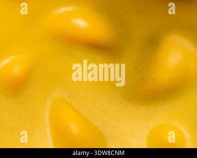 Close-up of a yellow textured surface with rounded bumps and soft shadows. Abstract background with organic shapes and smooth plastic or rubber materi Stock Photo