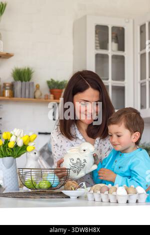 Happy Family Preparing for Easter at Home, Mom and Child Coloring Eggs, Festive Atmosphere, Spring Holiday and Parenting Lifestyle Stock Photo