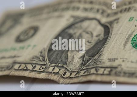 extreme close up of a crumpled worn one dollar bill focusing on george washington portrait, symbolizing financial crisis, inflation, and old us curren Stock Photo