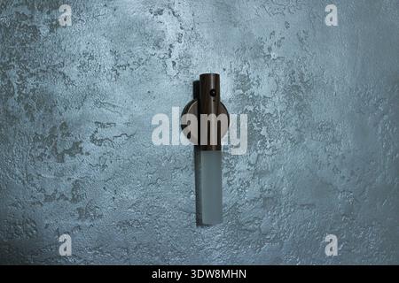 Smart eco-friendly lamp with motion sensor on the gray decorative wall. Stock Photo