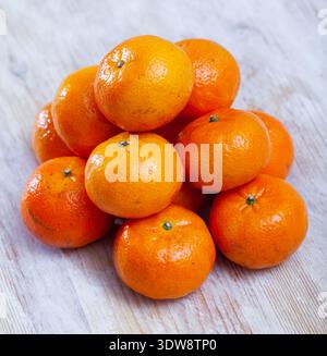 Closeup of fresh sweet clementines on wooden table Stock Photo