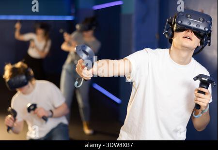 Portrait of young man with virtual reality glasses standing in room Stock Photo