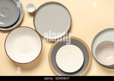 Stylish ceramic plates and bowls on beige background Stock Photo