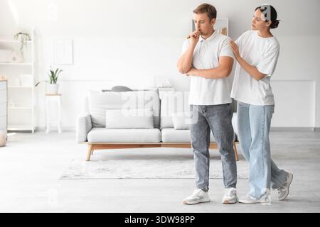 Young woman supporting sad man with suicidal thoughts at home Stock Photo