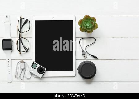 Composition with modern gadgets and eyeglasses on light wooden background Stock Photo