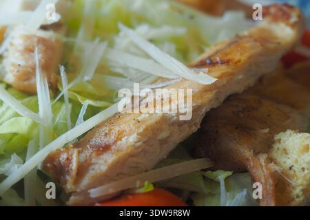 Fresh salad with grilled chicken and cheese strips on top Stock Photo