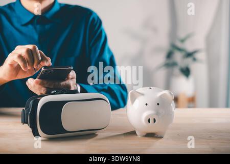 Bank piggy save future metaverse virtual digital technology reality vr system helps man using smartphone, planning financial investment and wealth gro Stock Photo