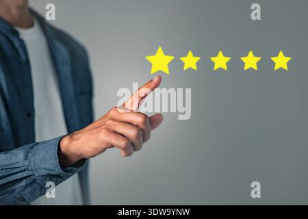 Customer five star review rate concept with hand pressing for a good rating shown on the screen, reflecting positive feedback showing a reputable cust Stock Photo