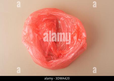 Red crumpled plastic bag representing waste and environmental pollution Stock Photo