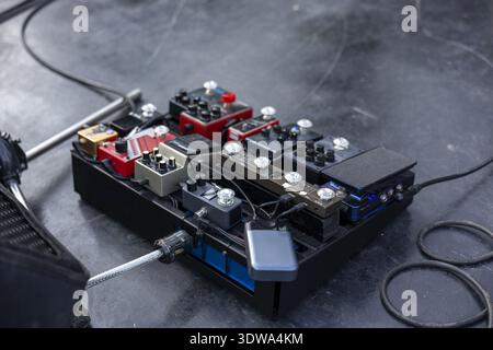 Professional guitar pedalboard setup with various effect stompbox for creating unique sound. Music equipment on stage floor, ready for passionate perf Stock Photo