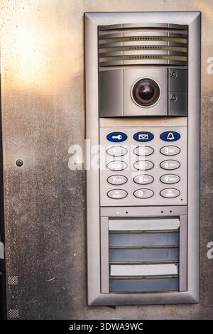 Modern metal intercom with keypad and camera mounted on building entrance Stock Photo