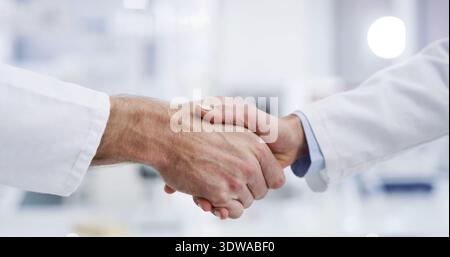 People, doctor and meeting with handshake for partnership, agreement or teamwork in hospital. Closeup, employees or healthcare workers shaking hands Stock Photo