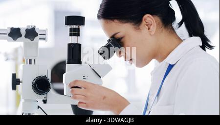 Microscope, science and research with woman in laboratory for study, drug development or test. Pharmacy trial, biology report and medical solution Stock Photo