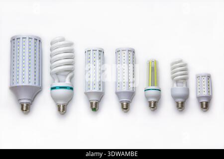 Row of various LED corn lights and compact fluorescent spiral bulbs on clean white background; showing modern lighting options; efficiency; design and Stock Photo