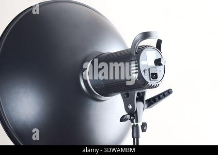 High power studio light head with metal beauty dish on stand, clean minimal look, ideal for portrait, fashion and product lighting in modern photo stu Stock Photo