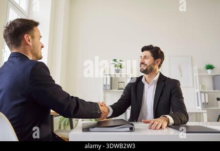 Positive Businessman Shaking Hands With Colleague In Office Stock Photo
