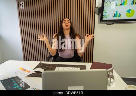 Woman focusing on mindfulness in a corporate office environment Stock Photo