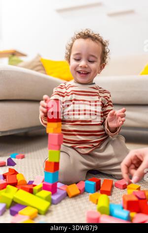 Happy toddler building tower with colorful wooden blocks Stock Photo