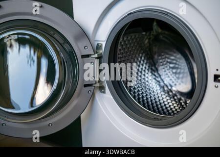 Close view of an open front loading washing machine showing the stainless steel drum inside. Stock Photo