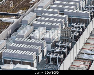 Aerial view of a data center's rooftop reveals a symphony of gray cooling systems arranged in neat rows, Iron Mountain Data Center, Frankfurt am Main, Stock Photo