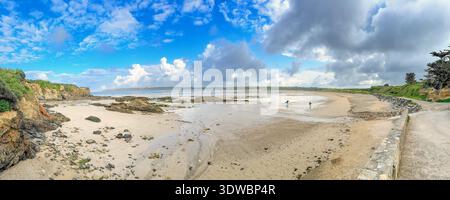 Panoramic view with surfers walking on a beach to the seaPanoramic view with surfers walking on a beach to the sea Stock Photo