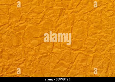 Crumpled orange paper texture background with wrinkled surface for design Stock Photo