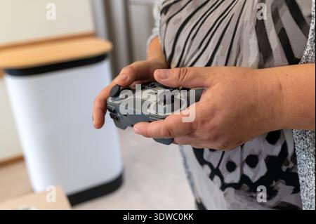 Hands using a game controller to operate a robot in a technology workshop Stock Photo
