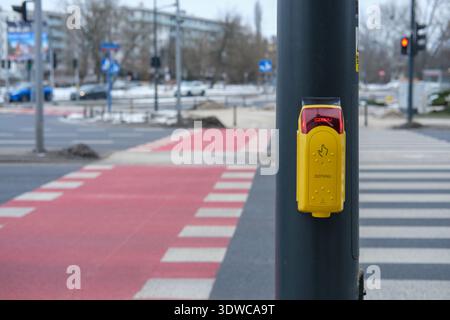 Pedestrian crossing request button with red signal illuminated on traffic light pole at urban intersection Stock Photo