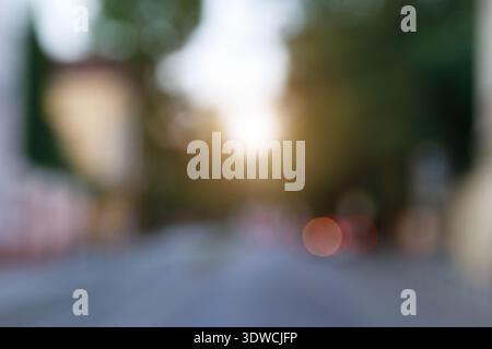 A dreamy, out-of-focus view of a street bathed in the golden glow of sunset, with blurred lights creating a magical atmosphere Stock Photo