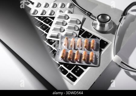 doctor's laptop computer keyboard with tablets and stethoscope Stock Photo