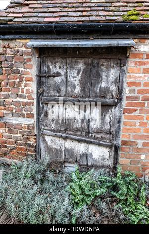 Old wooden door to a residence in Coggeshall, Essex Stock Photo