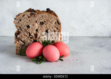 Easter cake with chocolate drops, pink-colored eggs on gray background. Traditional Easter concept. Stock Photo