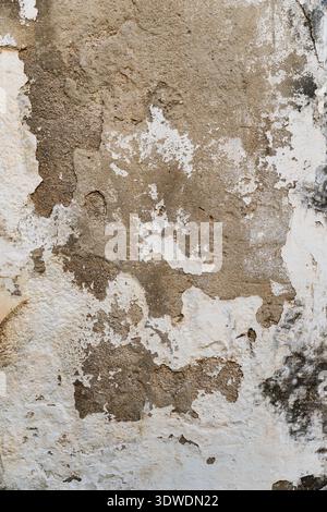 texture of an old wall with partially peeling white plaster Stock Photo