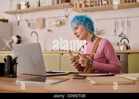 Vibrant young woman engages in creative work, showcasing her unique style in a cozy space. Stock Photo